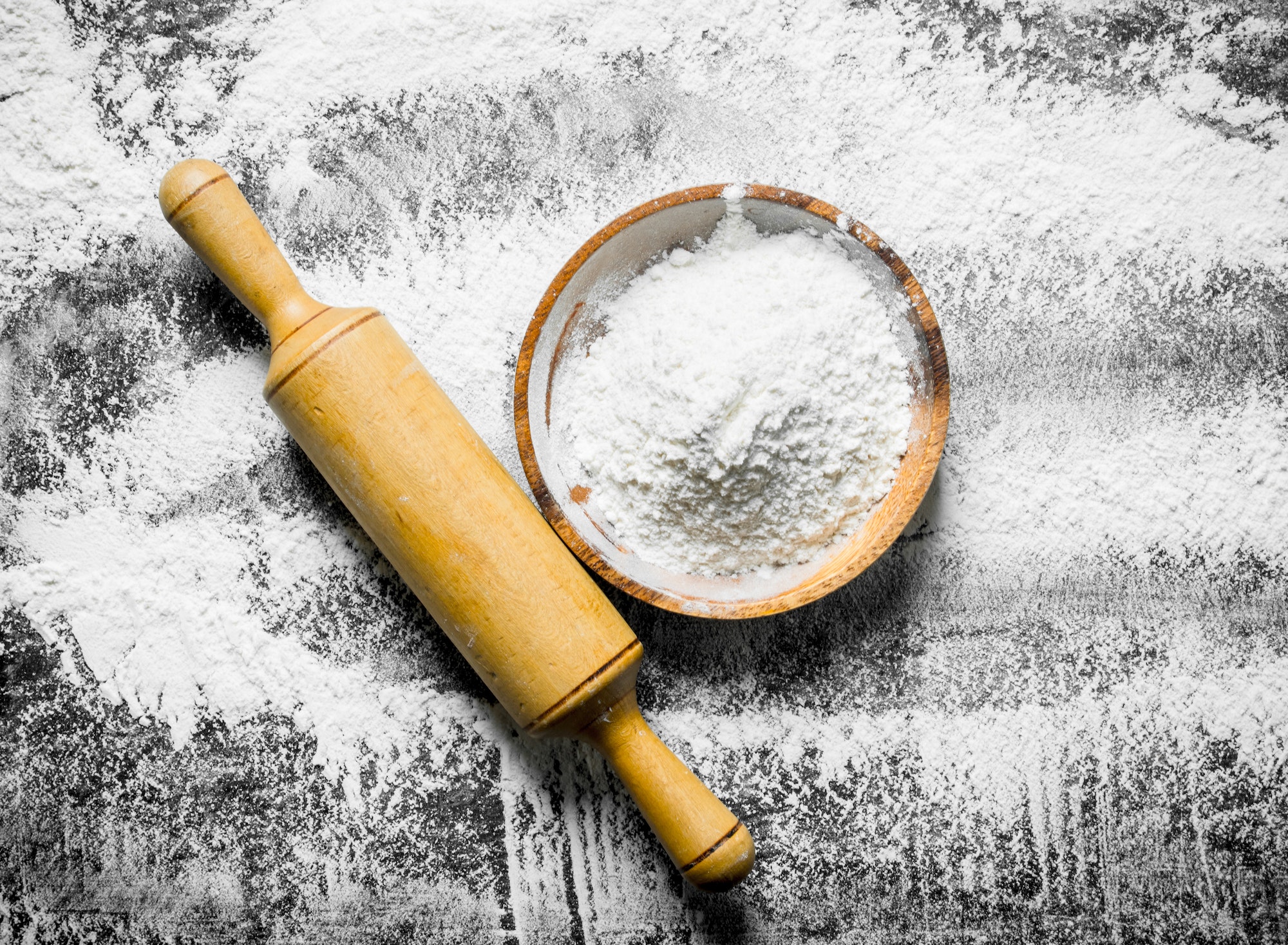 Flour background. Flour on a plate with a rolling pin.